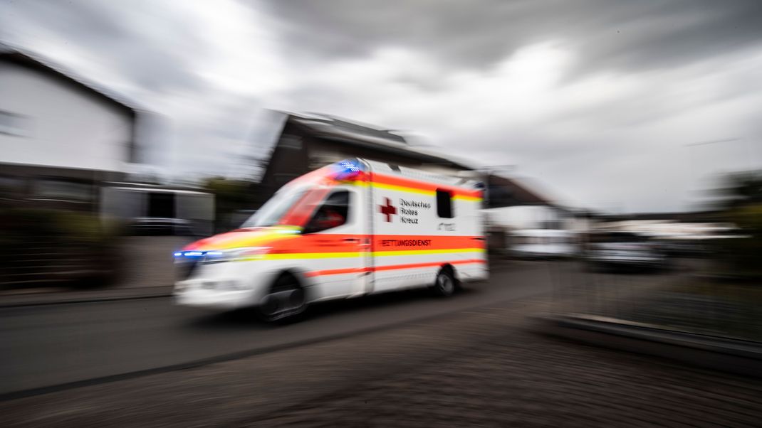 Ein Rettungswagen des Deutschen Roten Kreuzes fährt durch eine Straße.