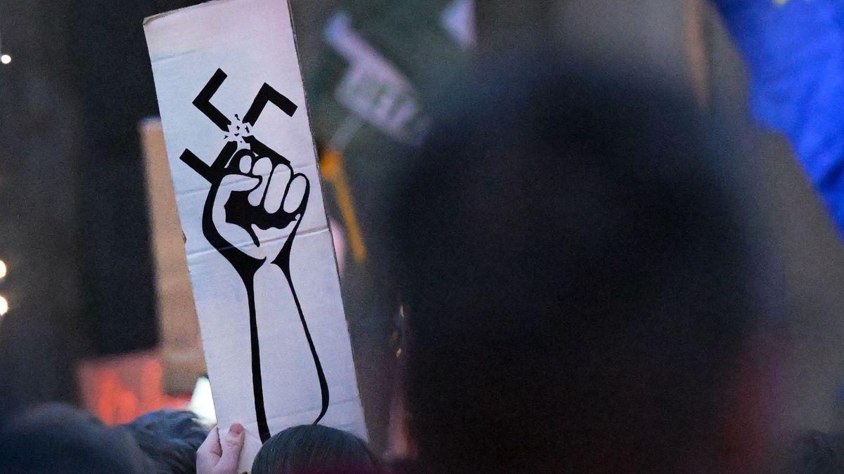 Menschen halten Schilder auf der Demonstration "Lichtermeer gegen den Rechtsruck" am Brandenburger Tor hoch.