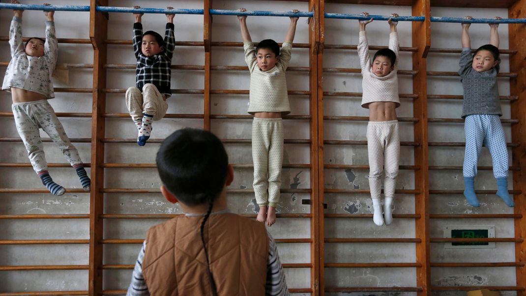 Eine Gruppe junger Turner während einer Trainingseinheit in der Turnhalle einer Sportschule in Jiaxing, Provinz Zhejiang (China).