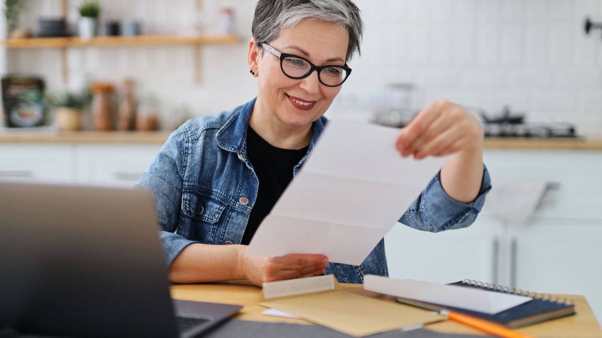 Happy mature woman received payment confirmation in the mail, good news.