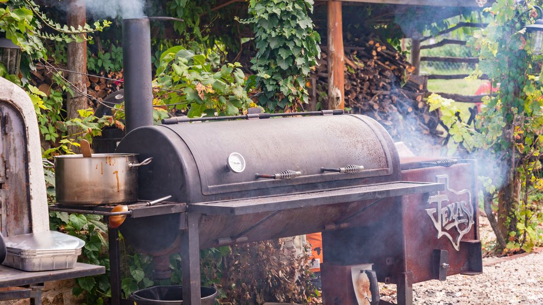 In einem Smoker kannst du hervorragend Fleisch über lange Zeit garen lassen. Der rauchige Geschmack ist dabei charakteristisch.