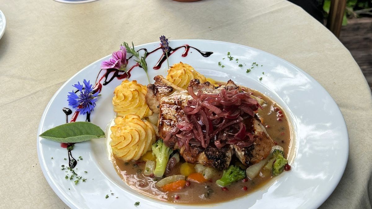 Gegrilltes Schweinekottelet mit roten Zwiebeln auf Cognac-Pfeffersoße mit Gemüse und Herzoginkartoffeln