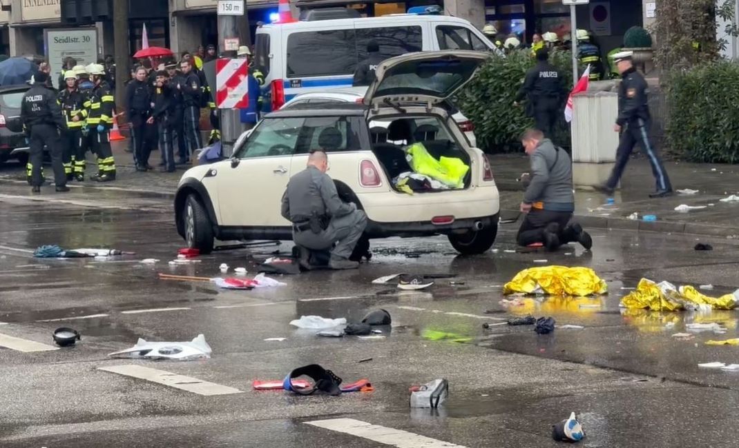 olizisten untersuchen ein Auto in der Nähe des Einsatzortes.