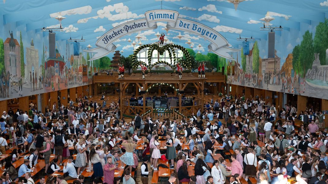 Die ersten Besucher sitzen in einem Bierzelt.