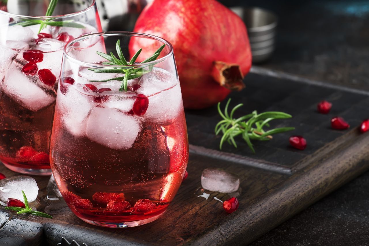 Cocktail mit Wodka, Granatapfel-Saft, Eiswürfeln und Rosmarin.