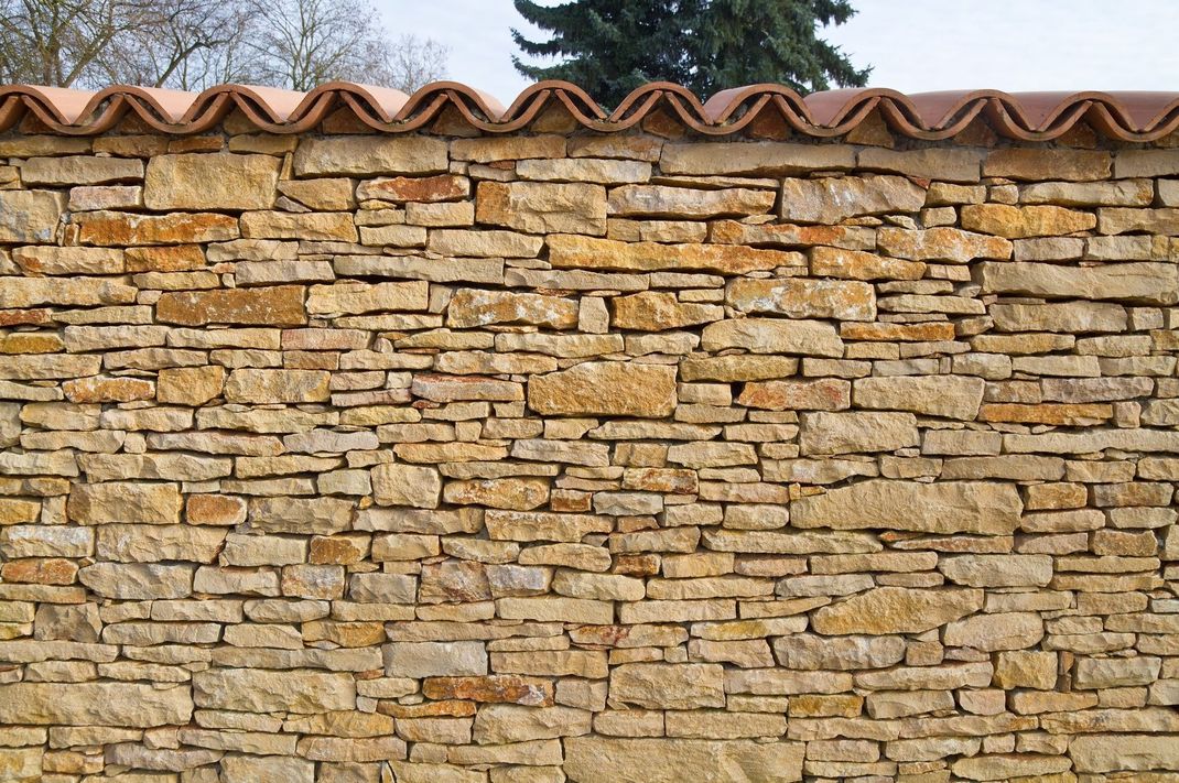 Beton, Granit und Co. passen nicht in jeden Garten. Besonders gut auf Natursteinmauern beispielsweise sehen Ziegel aus.