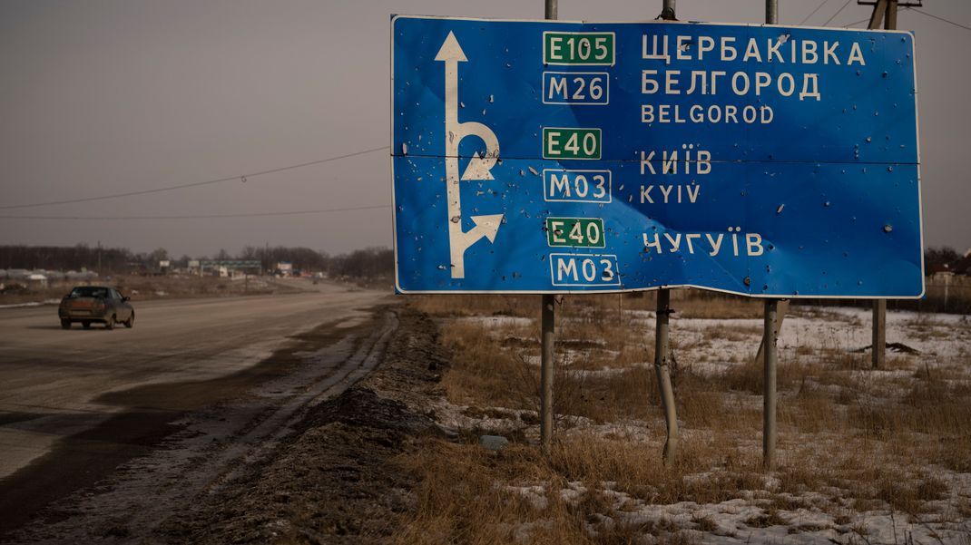 Ein von Kugeln und Granatsplittern beschädigtes Straßenschild zeigt Richtung der russischen Stadt Belgorod.