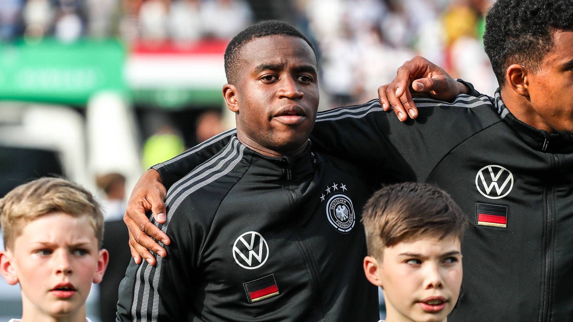 
                <strong>Youssoufa Moukoko</strong><br>
                Moukokos Zeit in der U21 war von zahlreichen Verletzungen geprägt, bei der EM kam er während der im März 2021 gespielten Gruppenphase nicht zum Einsatz und verpasste die Finalrunde im darauffolgenden Juni komplett. Als 17-Jähriger wurde er ohne vorherige Länderspiel-Nominierung in den WM-Kader für Katar berufen und gab im Testspiel vor dem Turnier gegen den Oman sein Debüt. Drei Tage nach seinem 18. Geburtstag kam er im ersten WM-Spiel gegen Japan als Joker ins Spiel und brach damit den Rekord als jüngster deutscher Spieler in der WM-Geschichte.
              