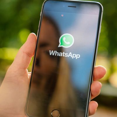 AACHEN, GERMANY AUGUST 2019: Woman holding a Apple iPhone opening Whatsapp app in a car. WhatsApp messenger for sending messages via the Internet 