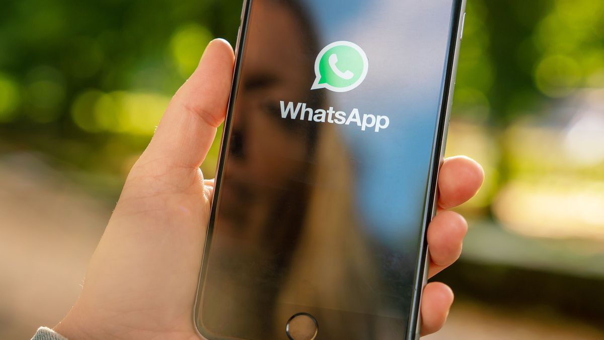 AACHEN, GERMANY AUGUST 2019: Woman holding a Apple iPhone opening Whatsapp app in a car. WhatsApp messenger for sending messages via the Internet 