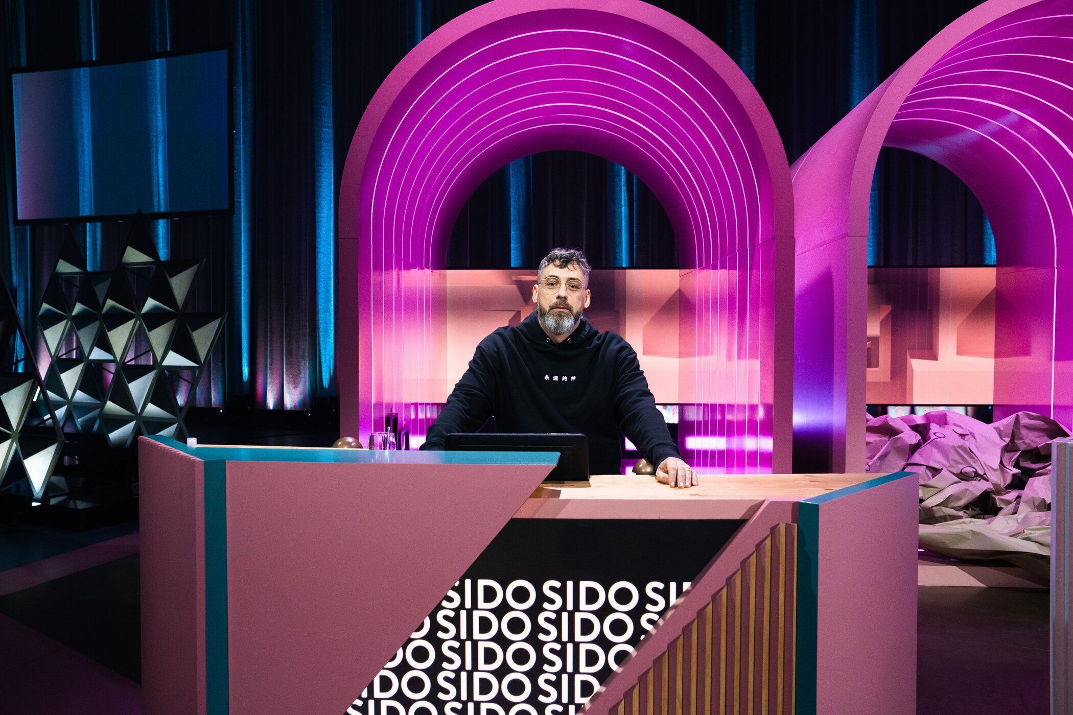 Sido sitzt an einem Ratepult im "Wer stiehlt mir die Show?"-Studio