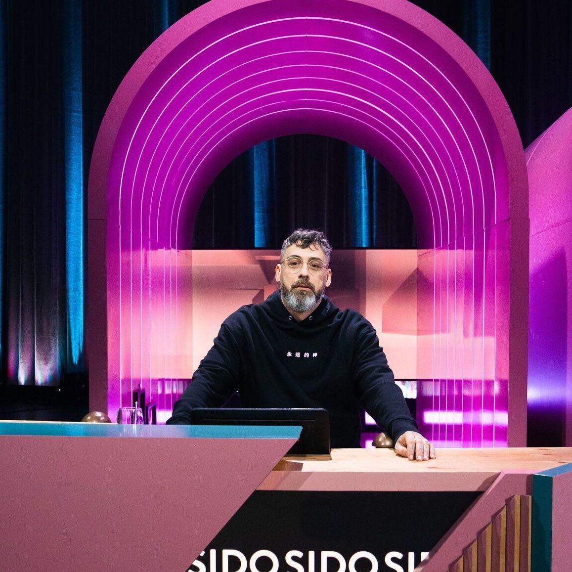Sido sitzt an einem Ratepult im "Wer stiehlt mir die Show?"-Studio