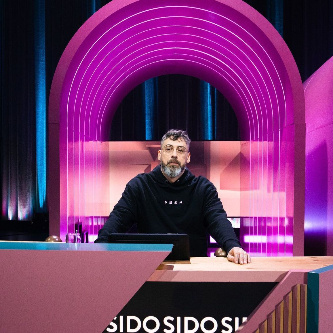Sido sitzt an einem Ratepult im "Wer stiehlt mir die Show?"-Studio