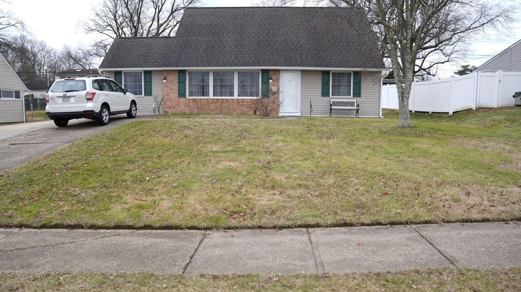 Ein Fahrzeug ist in der Einfahrt eines Hauses geparkt, das Schauplatz eines Mordes war. 