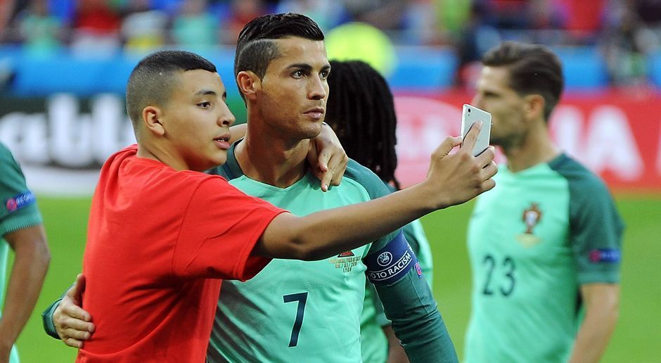 
                <strong>Selfie-Time</strong><br>
                ... posiert mit dem Fan für ein Selfie. Schon zum zweiten Mal bei dieser EM erfüllt CR7 damit den Foto-Wunsch eines Flitzers.
              