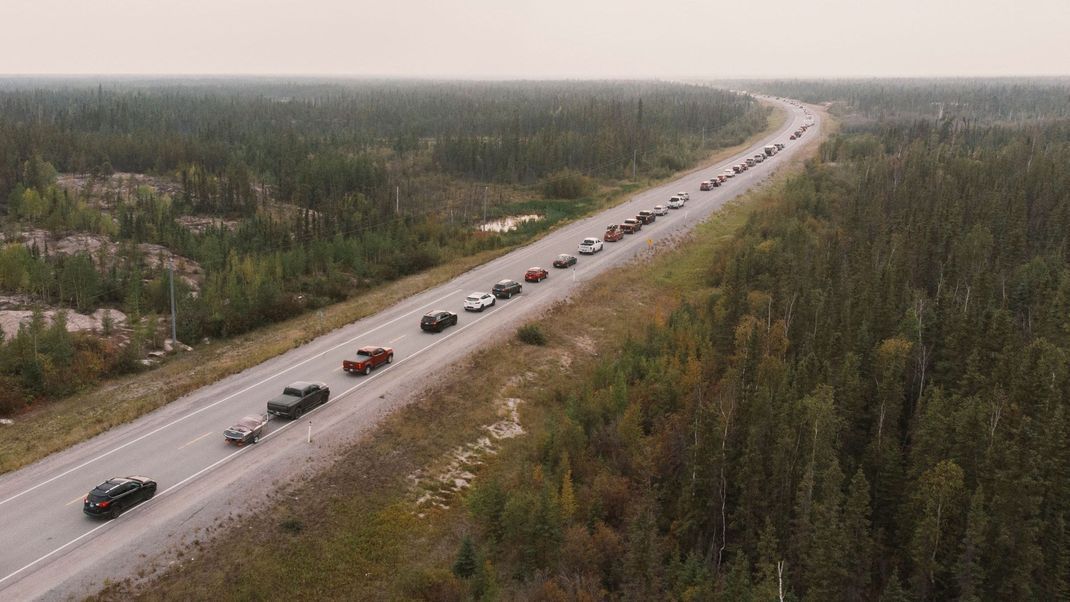 Die Bewohner:innen von Yellowknife verlassen die Stadt auf der Flucht vor dem Feuer über den Highway 3.