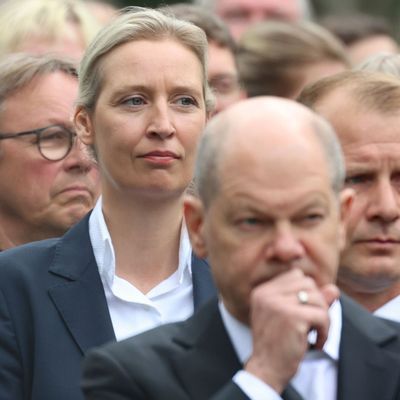 AfD-Chefin Weidel steht hinter Bundeskanzler Scholz bei einer Gedenkfeier.