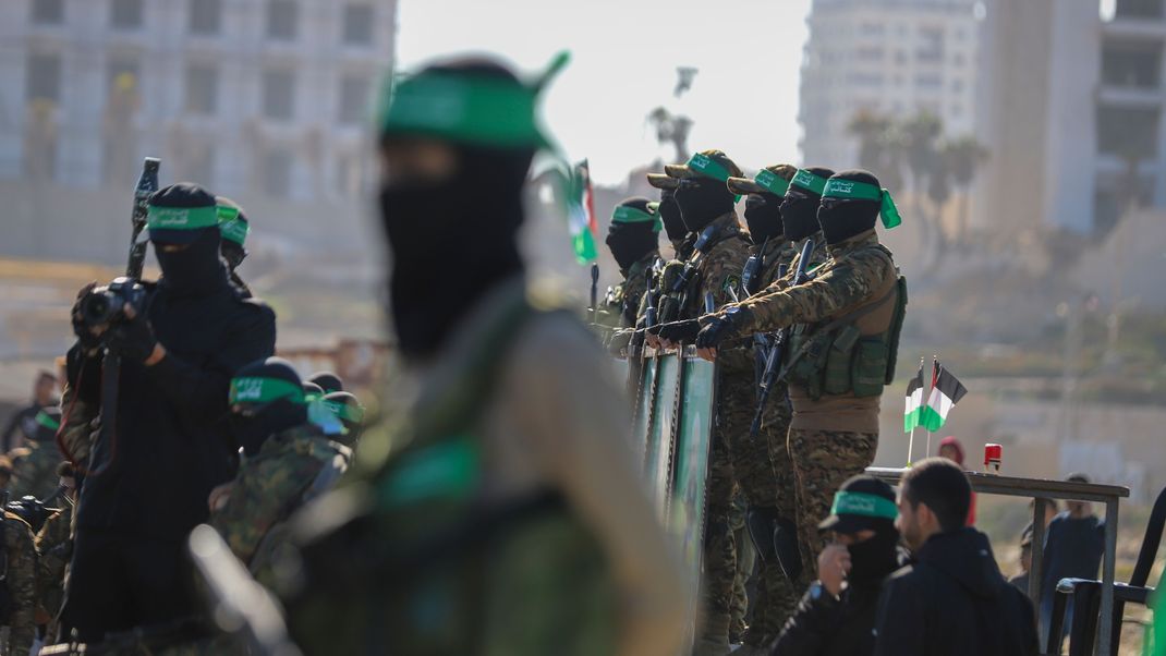 ARCHIV - 01.02.2025, Palästinensische Gebiete, Gaza-Stadt: Hamas-Kämpfer stehen am Ort der Übergabe einer Geisel an das Rote Kreuz in der Stadt Gaza.