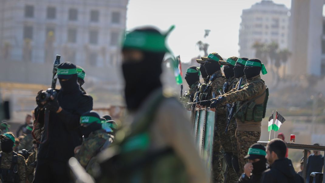 ARCHIV - 01.02.2025, Palästinensische Gebiete, Gaza-Stadt: Hamas-Kämpfer stehen am Ort der Übergabe einer Geisel an das Rote Kreuz in der Stadt Gaza.