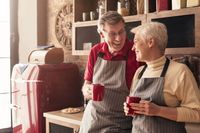 Senior man and woman having nice morning talk with coffee in kitchen