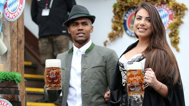 
                <strong>Douglas Costa</strong><br>
                Auf dem Platz kann der verletzte Douglas Costa derzeit leider nicht mithelfen, doch am Oktoberfest ist er natürlich mit dabei mit den Bayern-Kollegen - und seiner Ehefrau Luisa Ramos.
              