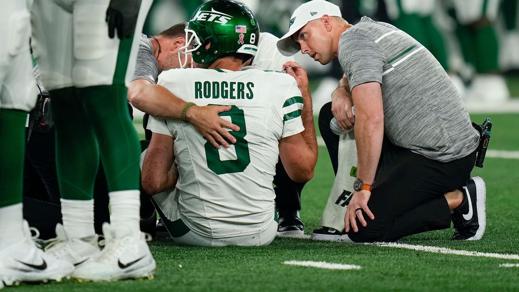 New York Jets-Quarterback Aaron Rodgers (8) wird auf dem Spielfeld betreut.