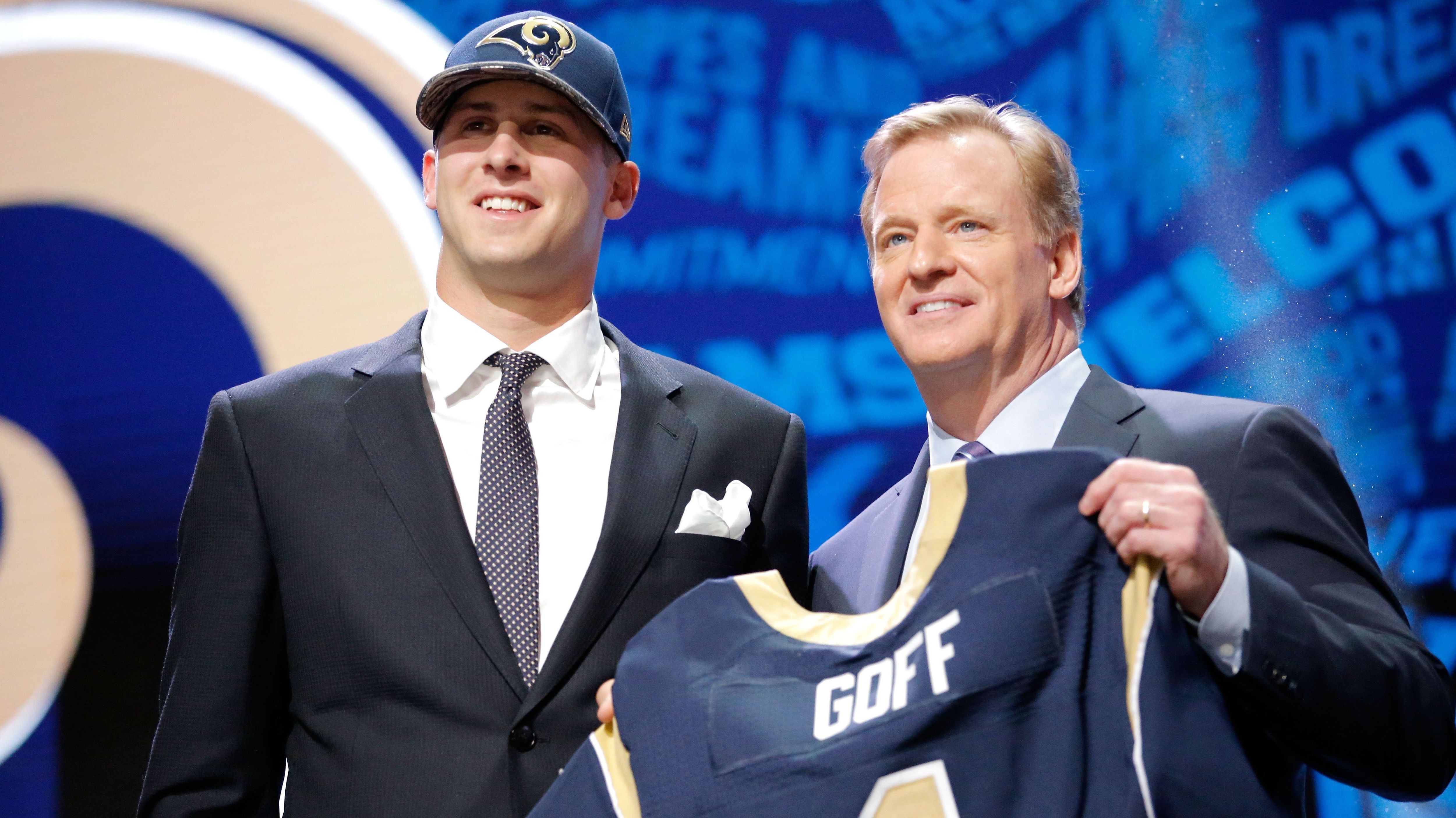 
                <strong>Jared Goff (1. Pick im Draft 2016, Los Angeles Rams)</strong><br>
                Püntklich zum Umzug nach Los Angeles sicherten sich die Rams im Draft 2016 mit Jared Goff einen Lokal-Matadoren. Dafür griff das Team tief in die eigene Tasche (1st, 2nd und 3rd-Round-Pick 2016 + 1st und 3rd 2017) und tradeten von Position fünfzehn an den Sonnenplatz der Tennessee Titans nach oben. Einen Platz dahinter sicherten sich die Philadelphia Eagles mit Carson Wentz ebenfalls einen Playmaker. Die Denver Broncos sollten mit Pick 26 für Paxton Lynch ebenfalls in der ersten Runde zuschlagen.
              