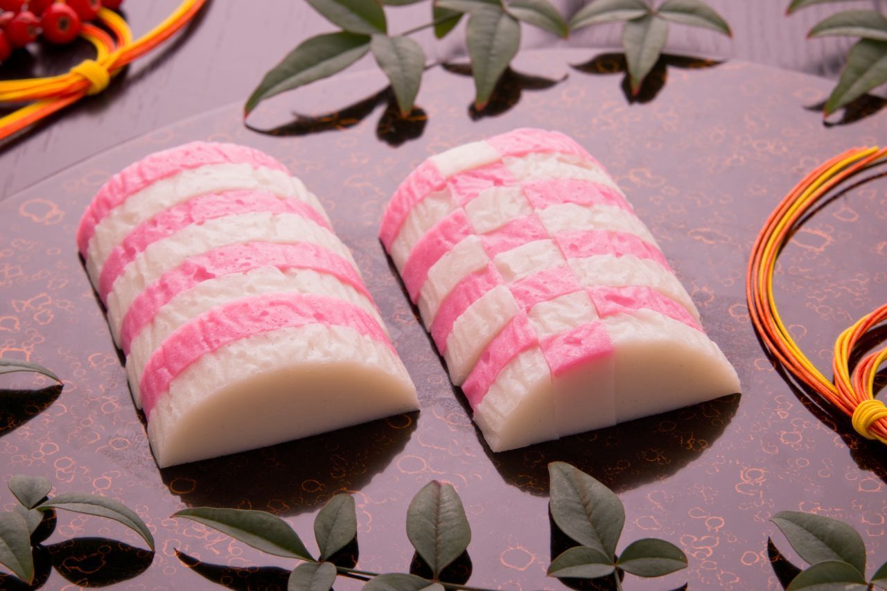 Kamaboko: Scheiben von püriertem, gedämpftem und geformtem Fisch-Fleisch (mit rötlicher und weißer Haut)
