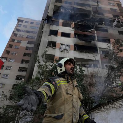 Ein Feuerwehrmann ist am Ort einer Explosion in einer Wohnanlage im Einsatz. 