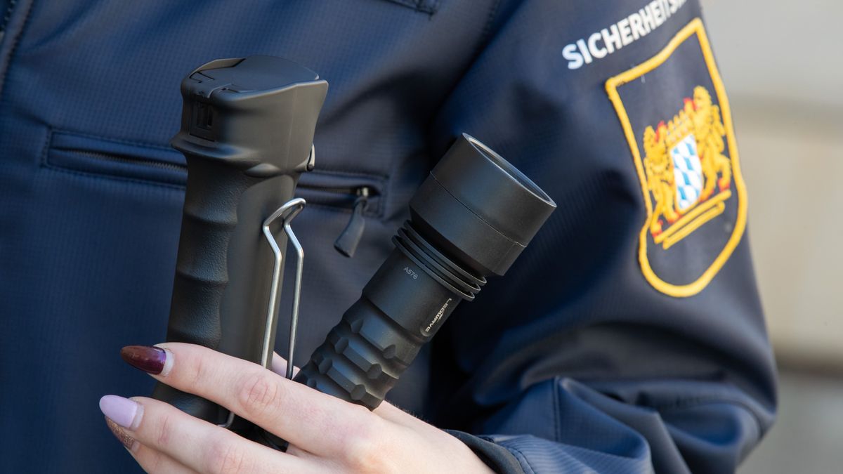 Ein Mitglied der bayerischen Sicherheitswacht präsentiert neue Kleidung sowie ein Pfefferspray und eine Taschenlampe.