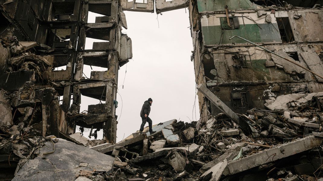 Ein Anwohner im ukrainischen Borodjanka sucht nach der Bombardierung durch Russland in den Trümmern eines zerstörten Wohnhauses nach Habseligkeiten.
