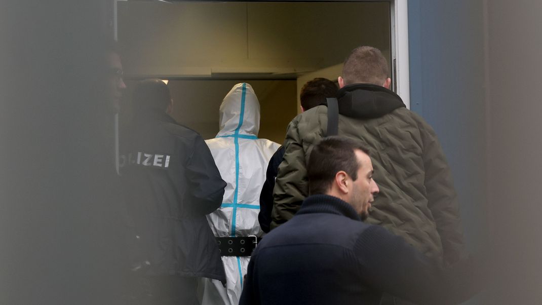 Polizeibeamte begleiten den mutmaßlichen Täter