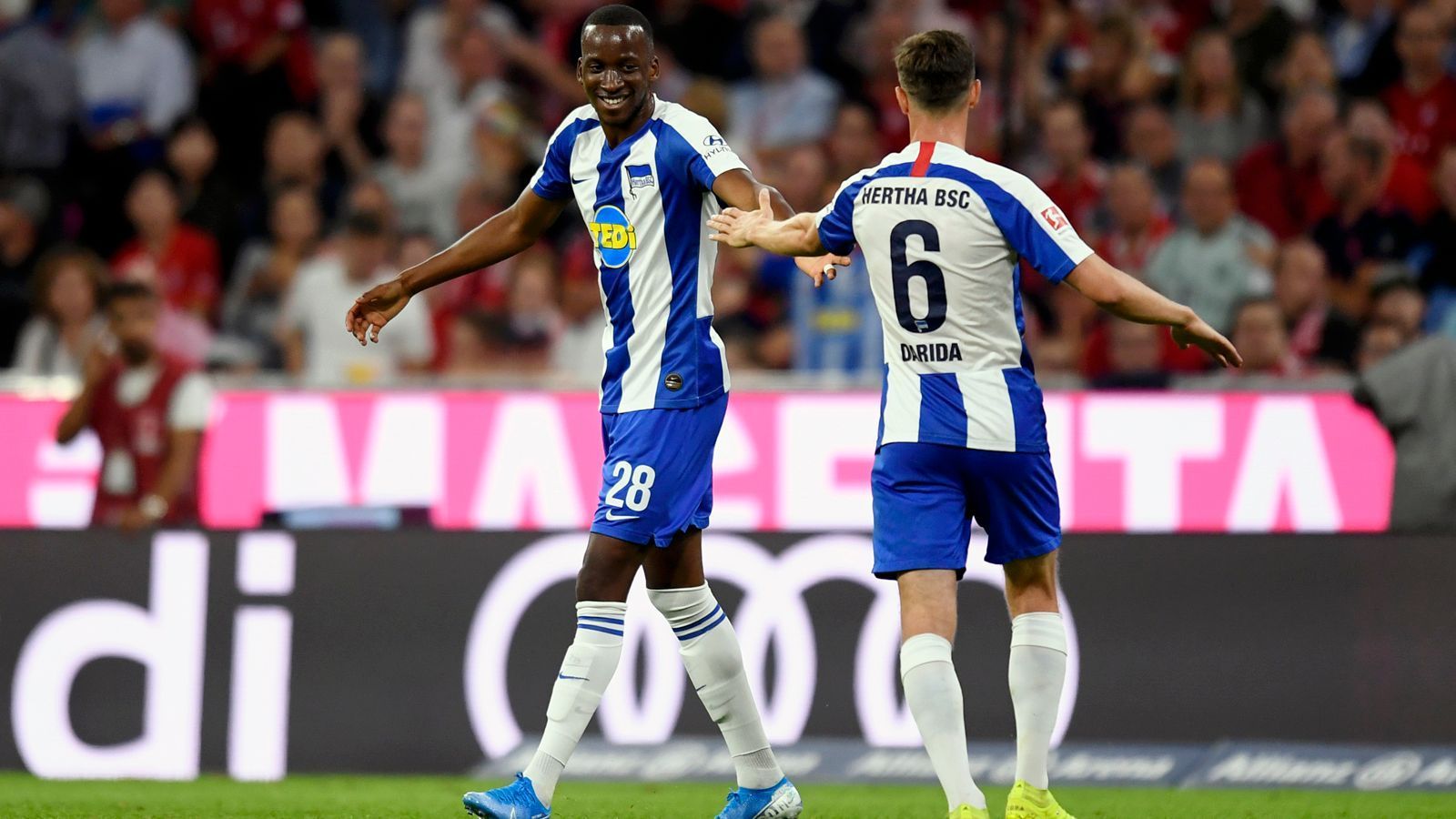 
                <strong>Schon vier Tore! Allianz-Arena-Schreck Dodi Lukebakio</strong><br>
                Herthas Neuzugang Dodi Lukebakio (li.) schockte beim 2:2-Unentschieden zum Bundesliga-Auftakt der Saison 2019/20 in der Allianz Arena einmal mehr den FC Bayern München. Mit seinem Treffer zum zwischenzeitlichen 1:1-Ausgleich traf der Belgier schon zum vierten Mal in der Bundesliga auswärts gegen den FCB - so oft, wie kein anderer Spieler in der bisherigen Bundesliga-Historie. In der Vorsaison war der Stürmer von Watford an Düsseldorf verliehen und traf beim 3:3-Unentschieden der Fortuna in München sogar drei Mal. Insgesamt stehen für Lukebakio bereits fünf Tore gegen die Bayern zu Buche, denn auch in der Rückrunde schlug er gegen die Münchner im Heimspiel der Düsseldorfer erneut wieder zu.
              