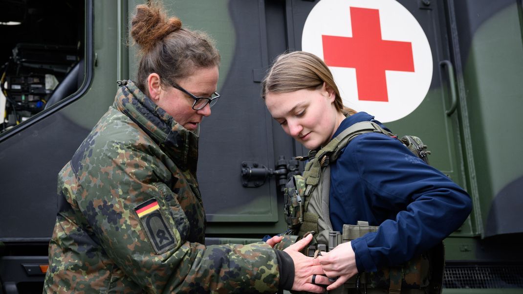 Hauptfeldwebel Julia (l.) legt beim Girls' Day (25. April) einer Schülerin eine gepanzerte Weste an. Der alljährliche Aktionstag soll Schülerinnen für Berufsbilder begeistern, die junge Frauen eher selten in Betracht ziehen.