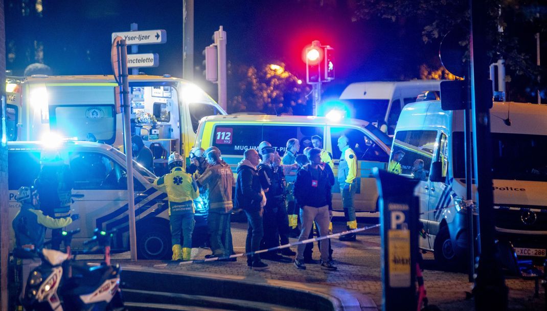 16.10.2023, Belgien, Brüssel: Polizisten stehen am Tatort. 