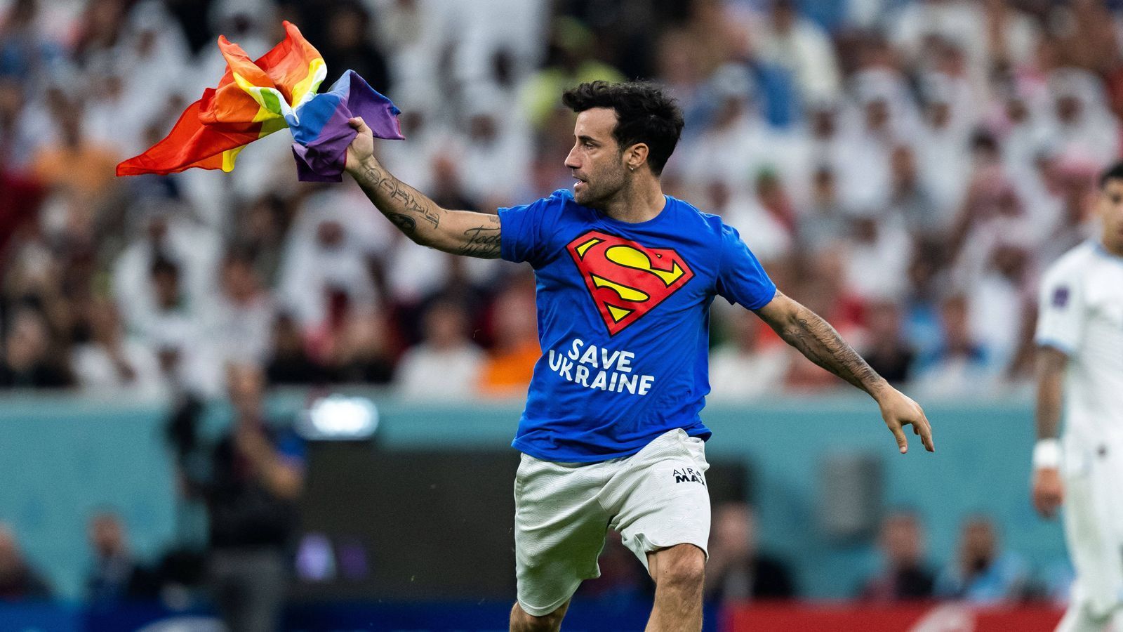 
                <strong>Cristiano Ronaldo gegen Uruguay: Sperenzchen, Flitzer, Achtelfinale!</strong><br>
                Wenige Minuten war die zweite Halbzeit alt, als ein Flitzer das Spielfeld im Lusail Stadium eroberte und über den Platz lief. Der unbekannte Mann trug ein Superman-T-Shirt mit der Aufschrift "Save Ukraine" sowie auf der Rückseite "Respect for Iranian Woman" und hatte dazu eine Regenbogen-Fahne in der Hand. Viel zu sehen war von ihm im Fernsehen aber nicht.
              