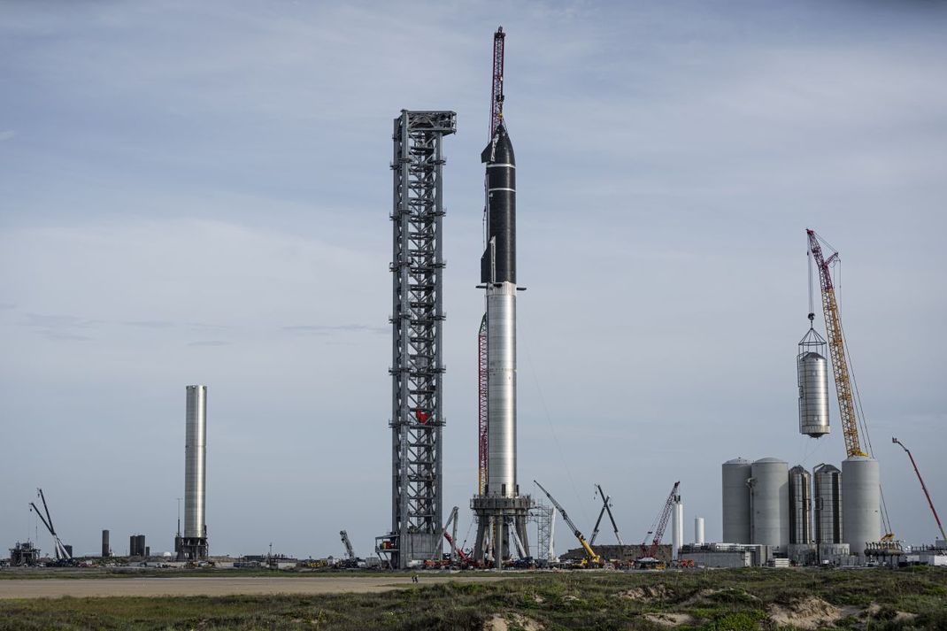 Vielleicht haben der Crew Dragon und die Falcon-9-Rakete in wenigen Jahren bereits ausgedient. Denn SpaceX baut an einem viel größeren Raumschiff (hier im Bild ein fast fertiger Prototyp im US-texanischen Boca Chica). Das zweiteilige Gespann aus Raumschiff und Rakete ist fast 5.000 Tonnen schwer. Das Starship soll Satelliten ins All transportieren und eines Tages Astronauten und Astronautinnen zum Mars fliegen.