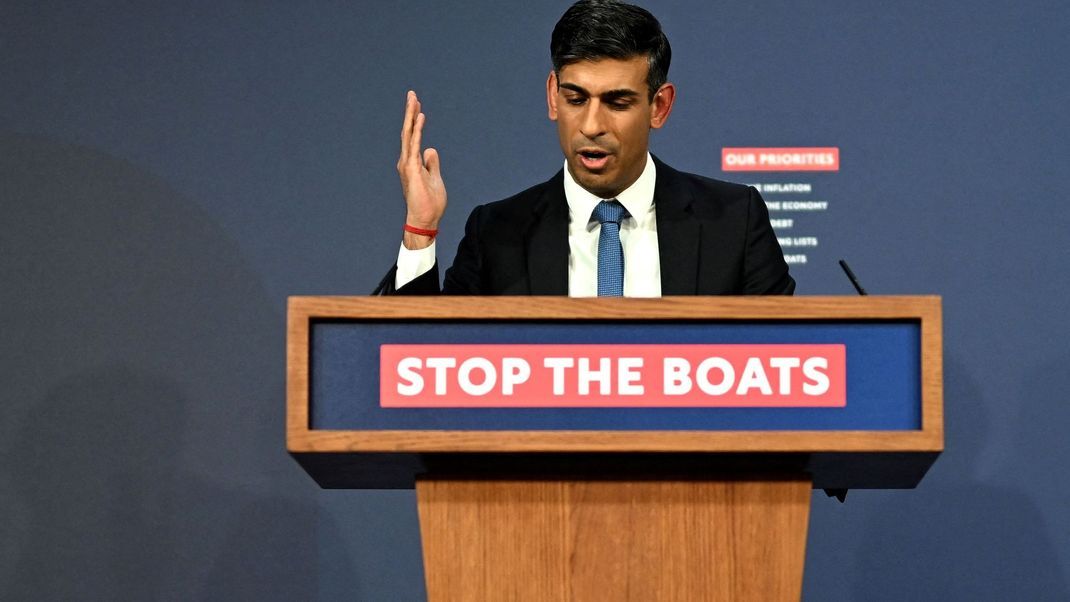 "Stop the Boats" (Stoppt die Boote) steht auf dem Rednerpult, während Premierminister Rishi Sunak das neue Asylgesetz verteidigt.