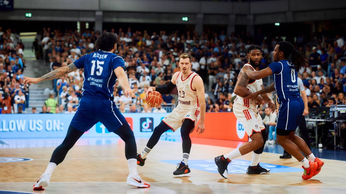 Drei Spieler von Andreas Obst (13; FC Bayern Basketball), Devin Booker (31; FC Bayern Basketball) und DJ Horne (0; MLP Academics Heidelberg) kämpfen um den Ball auf dem Court easyCredit BBL Playoff...