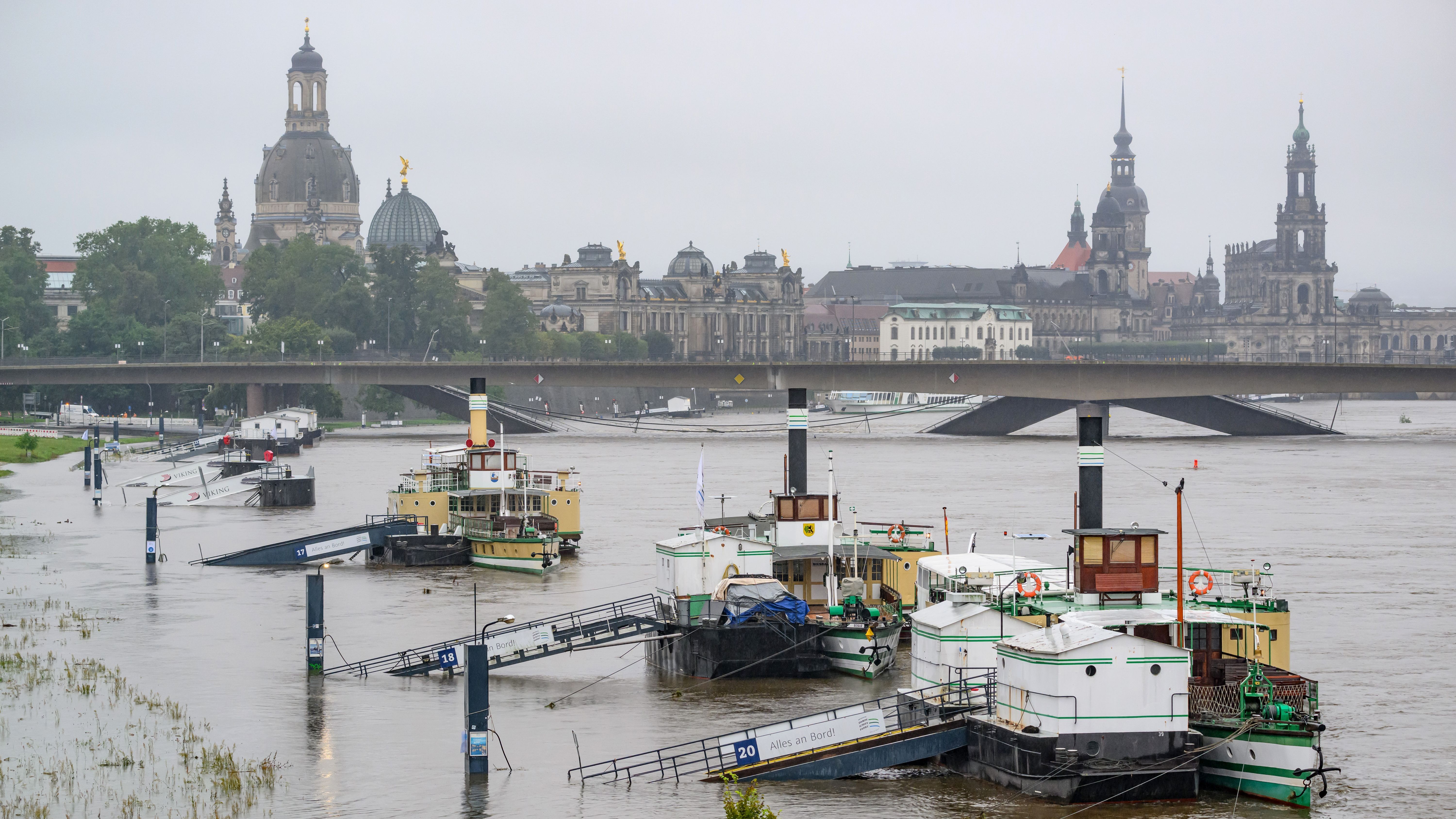 Dresden: Die Anleger für Schiffe der sächsischen Dampfschifffahrt sind vom Hochwasser der Elbe umspült, im Hintergrund ist die Altstadtkulisse und die teilweise eingestürzte Carolabrücke zu sehen.