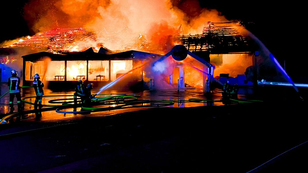 Niedersachsen, Sande: Einsatzkräfte der Feuerwehr löschen eine brennende Disco. 