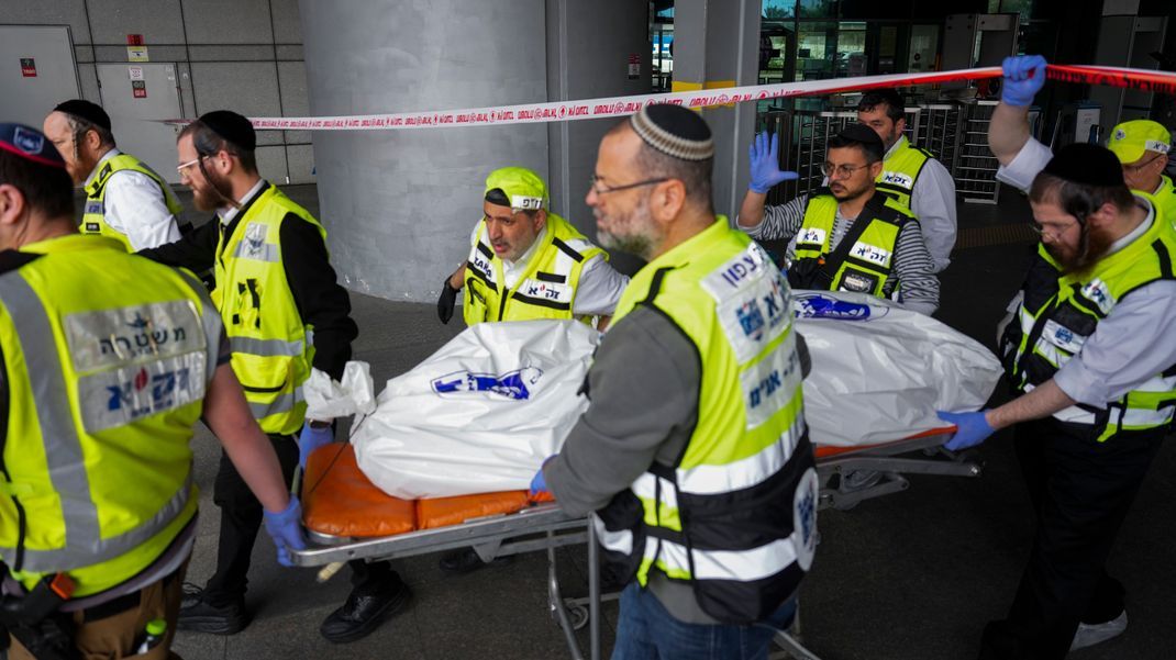 Mitglieder des ZAKA-Rettungsdienstes tragen die Leiche eines 70-Jährigen, der bei einem Messerangriff in Haifa, Israel, getötet wurde. Vier weitere Personen wurden bei dem Vorfall ebenfalls verletzt.