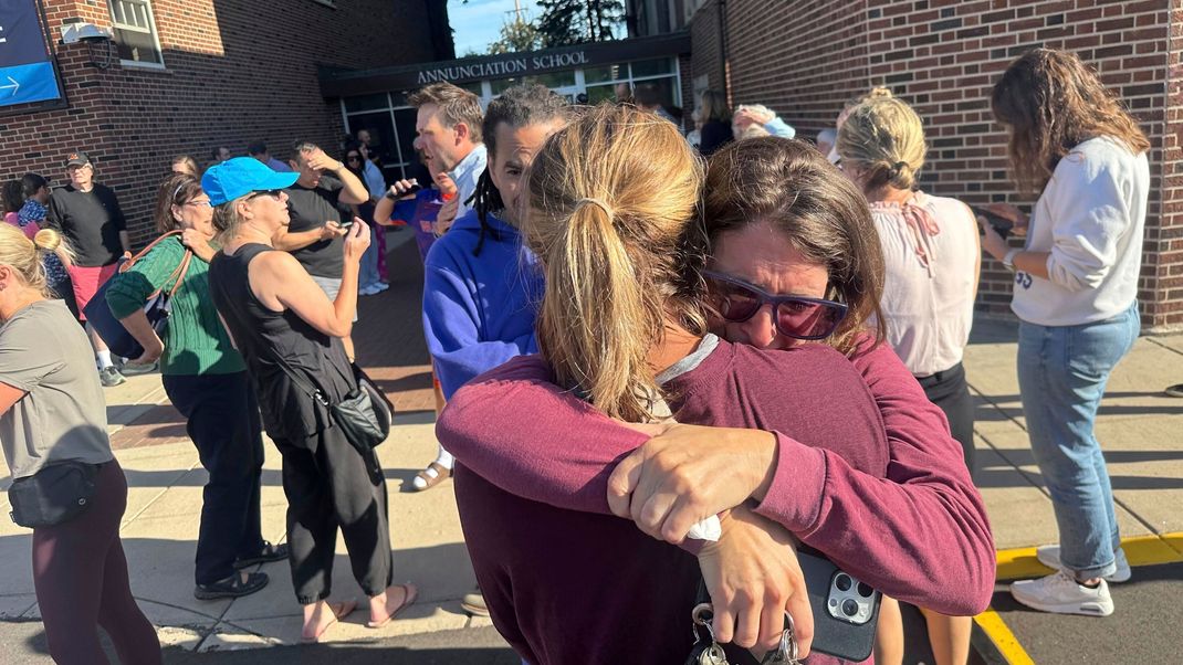 27. August 2025, USA, Minneapolis: Eltern vor der katholischen Schule, an der es zu einem Schusswaffenvorfall kam 