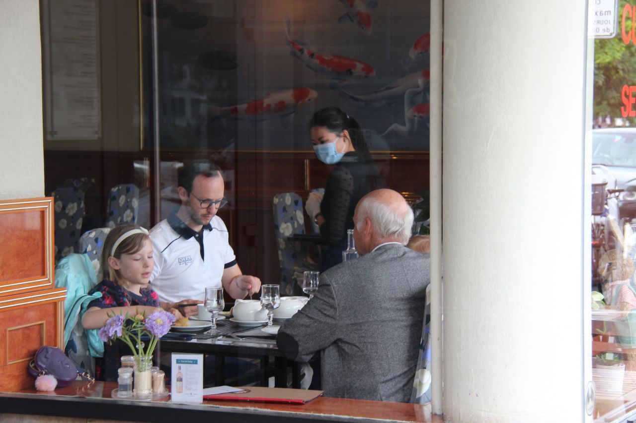 Schweiz, Genf: Menschen sitzen in einem Restaurant beieinander. Rund 8 Wochen nach der Schließung treten in der Schweiz Lockerungen der Corona-Einschränkungen in Kraft.