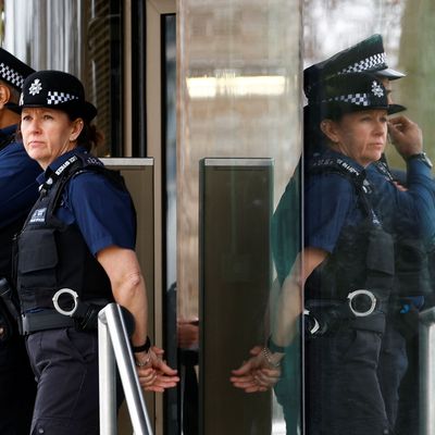 Polizist:innen stehen vor New Scotland Yard, dem Hauptquartier der Metropolitan Police in London.