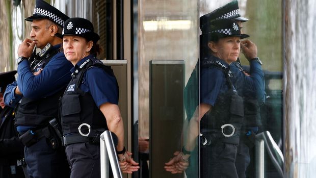 Polizist:innen stehen vor New Scotland Yard, dem Hauptquartier der Metropolitan Police in London.