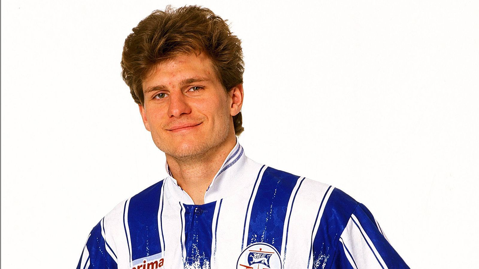 
                <strong>Steffen Baumgart</strong><br>
                Dieser Mann mit voller Haarpracht hielt sich von Mitte der 90er-Jahre an gut anderthalb Jahrzehnte im deutschen Profifußball und stand für Torgefahr. Na, erkannt? Es ist der heutige Köln-Coach Steffen Baumgart, der für Hansa Rostock, Wolfsburg, Union Berlin und Energie Cottbus stürmte und es in der Bundesliga und 2. Bundesliga auf 64 Treffer brachte.
              