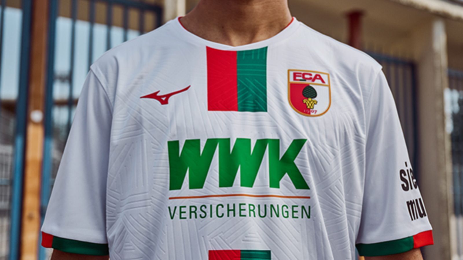 <strong>FC Augsburg </strong><br>Die Fuggerstädter setzen auf einen Traditionsstreifen in der Mitte des Trikots, der die "Symbiose zwischen Tradition und Moderne" darstellen soll. Zudem sind auch Elemente der Spielstätte der Augsburger, der WWK-Arena, dezent auf dem Trikot verewigt. Hier zu sehen ist das Heimtrikot, auswärts spielt der "FCA" in schwarzen Trikots.
