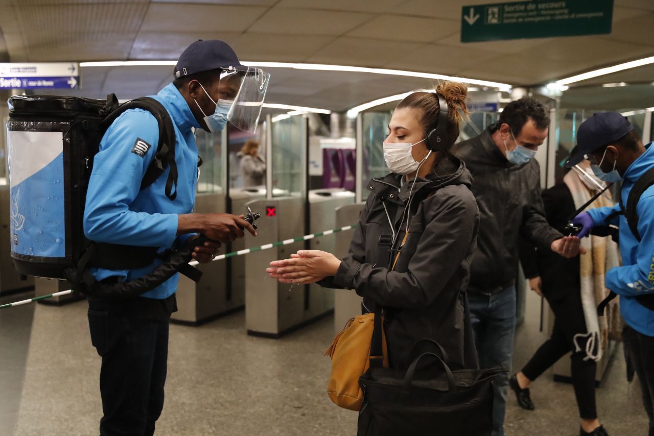 Frankreich, Paris: Mitarbeiter der Pariser Metro sprühen einem Pendler in einer Metrostation etwas hydroalkoholisches Gel auf die Hände. Nach 2 Monaten dürfen die Franzosen ihre Häuser und Wohnungen ohne Erlaubnisscheine verlassen. 