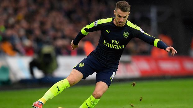 
                <strong>Aaron Ramsey</strong><br>
                Aaron Ramsey: Zeitgleich mit Wilshere kam auch der um ein Jahr ältere Ramsey in den Profi-Kader Arsenals. Wenger schnappte sich 2008 das walisische Toptalent von Cardiff City - und lag auch mit diesem Transfer richtig. Mit mittlerweile 26 Jahren ist Ramsey absoluter Leistungsträger im Mittelfeld der "Gunners", spielte bereits in 284 Pflichtspielen für die Engländer. Abgesehen von einem Schien- und Wadenbeinbruch in der Saison 2009/10 blieb er - im Gegensatz zu Wilshere - fast ausschließlich von schweren Verletzungen verschont. Die kürzliche 1:5-Klatsche in München erlebte Ramsey aber aufgrund einer Wadenverletzung nur auf der Tribüne.
              